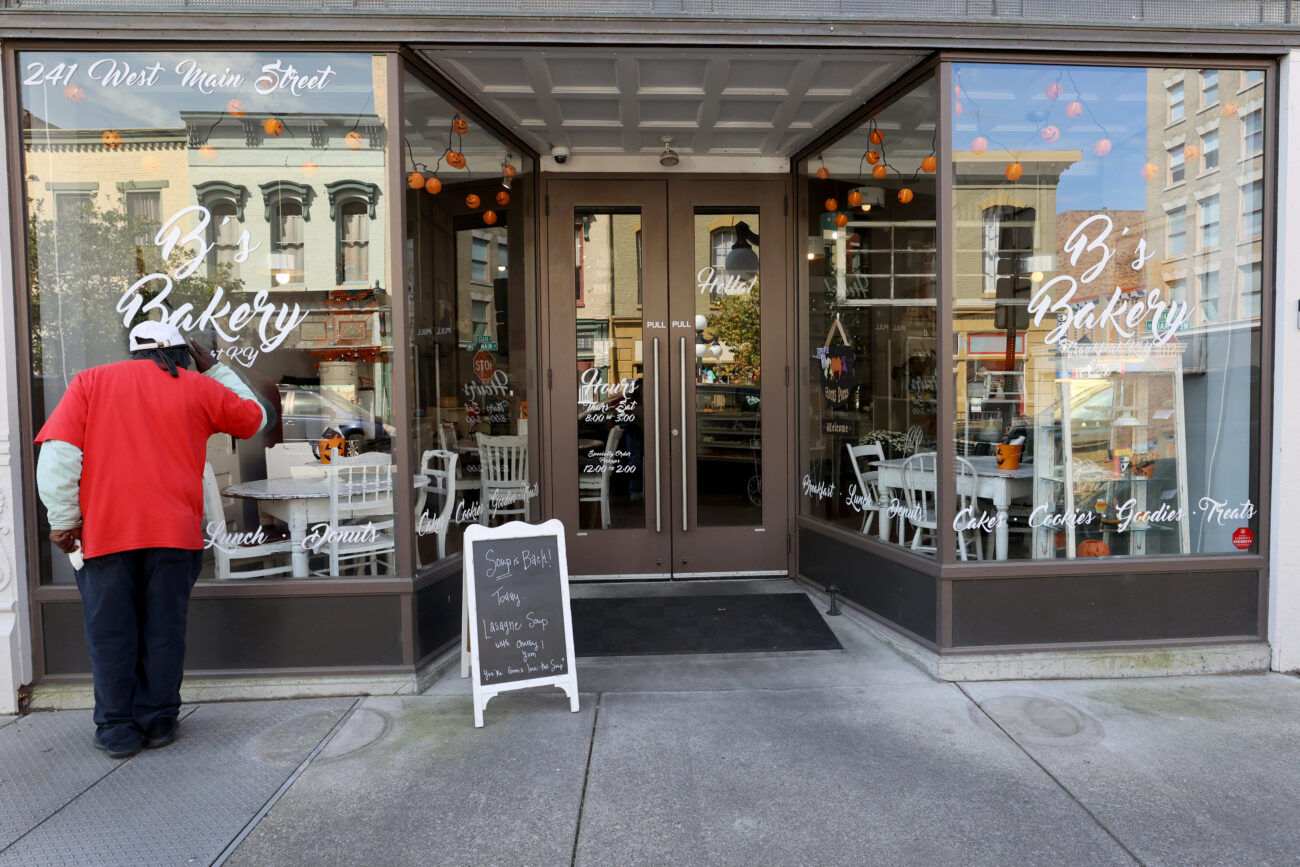 At the front of B’s Bakery in Frankfort KY, a person peers through the windows prior to opening on Oct. 8, 2022.